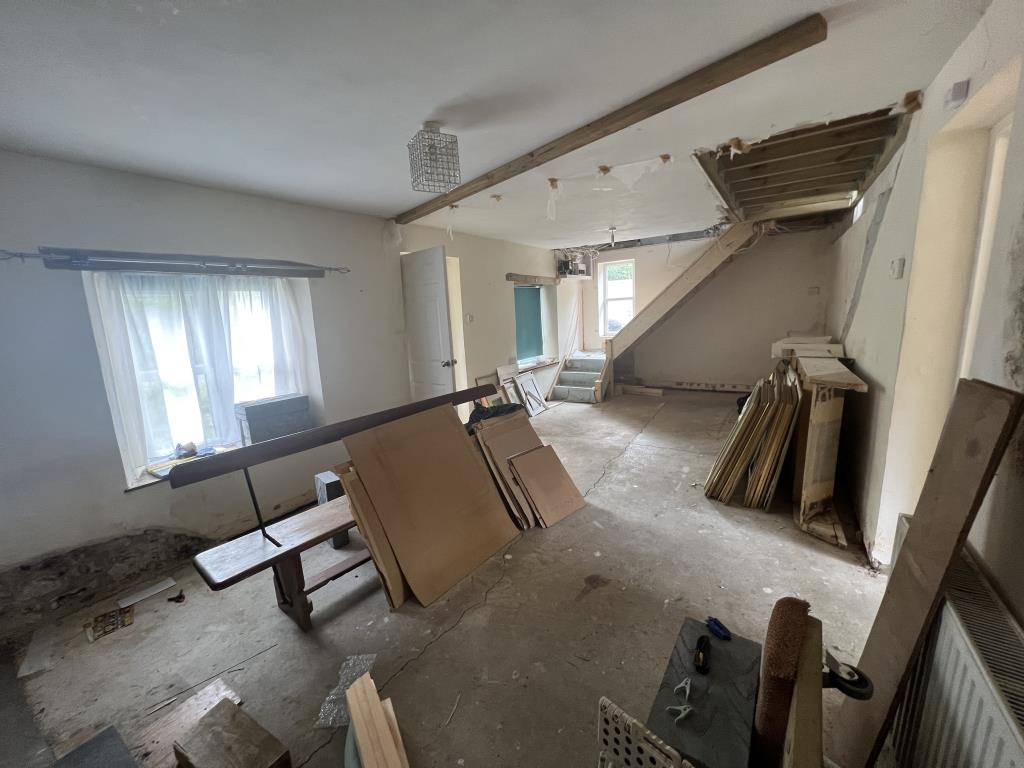 Lot: 153 - DETACHED COTTAGE FOR COMPLETE REFURBISHMENT - Living and dining room showing door to the porch